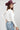 A woman wearing a classic long-sleeve tee features a flattering, fitted silhouette with an elegant boat neckline worn alone or styled as an effortless layering piece--Boat_Neck_Long_Sleeve_Top_-_Ivory-FleaStyle