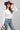 A woman wearing a classic long-sleeve tee features a flattering, fitted silhouette with an elegant boat neckline worn alone or styled as an effortless layering piece--Boat_Neck_Long_Sleeve_Top_-_Ivory-FleaStyle