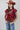 A woman wearing a maroon short-sleeve crewneck sweater with a red, orange, and white tiger print, paired with blue jeans and a rust cowboy hat-Tiger_Tapestry_Short-Sleeve_Sweater-FleaStyle