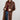 A woman wearing a long,  brown faux fur coat with a horse motif lining, paired with a rust-colored cowboy hat, a maroon tigher patterned top, and blue jeans against a gray background-Longline_Faux_Fur_Jacket_-_Brown-FleaStyle
