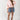 Woman wearing a Bubble-Sleeve-Button-Down-Top-Peony-Pink-Fleastyle, denim shorts, and cowboy boots and tie belt-Fleastyle