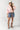 Woman wearing a Bubble-Sleeve-Button-Down-Top-Peony-Pink-Fleastyle, denim shorts, and cowboy boots and tie belt-Fleastyle