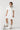 Woman in a Floral-Embroidery-Cut-Out-Mini-Dress-Ivory with a scarf, standing next to a soccer ball-Fleastyle