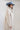 A woman wearing a taupe faux fur jacket featuring a plush, shaggy texture with an oversized fit and dramatic longline silhouette, paired with a dusty blue cowboy -Longline_Faux_Fur_Jacket_-_Taupe-FleaStyle