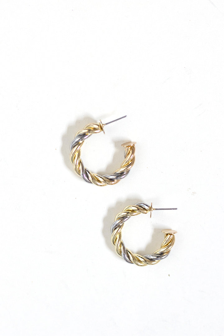 Close-up of mixed metal twisted hoop earrings in gold and silver tones, lightweight everyday jewelry for casual or dressy looks.