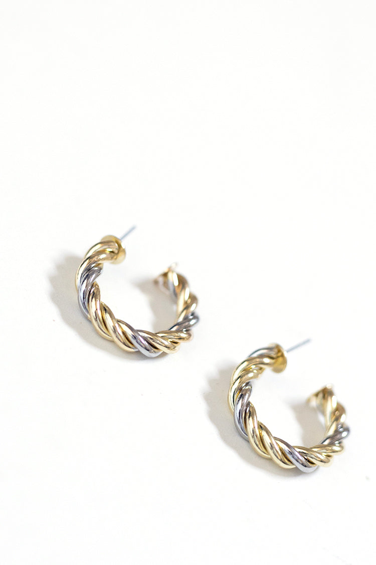 Close-up of mixed metal twisted hoop earrings in gold and silver tones, lightweight everyday jewelry for casual or dressy looks.