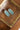 A pair of oval silver-toned concho-style earrings-with turquoise-colored inlay stones, displayed on a wooden surface next to a blue fabric-Western_Inspired_Scalloped_Earrings-FleaStyle.