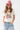 A woman wearing a pink cowboy hat and vintage-inspired graphic tee in a classic, relaxed t-shirt fit in a soft ivory hue with colorful retro-inspired Dolly Parton artwork, and light blue jeans, posing against a white studio background-Dolly_Western_Butterfly_Graphic_T-Shirt-FleaStyle