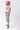 A woman wearing a pink cowboy hat and vintage-inspired graphic tee in a classic, relaxed t-shirt fit in a soft ivory hue with colorful retro-inspired Dolly Parton artwork, and light blue jeans, posing against a white studio background-Dolly_Western_Butterfly_Graphic_T-Shirt-FleaStyle