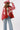 A woman wearing a red paisley jacket featuring an easy, relaxed silhouette with quilted detailing, contrasting stitching and beautiful lace appliqués that give it a cool, collected-over-time feel-Quilted_Jacket_with_Paisley_Patches_-_Red-FleaStyle
