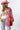 A woman wearing a red paisley jacket featuring an easy, relaxed silhouette with quilted detailing, contrasting stitching and beautiful lace appliqués that give it a cool, collected-over-time feel-Quilted_Jacket_with_Paisley_Patches_-_Red-FleaStyle