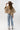A woman wearing a cropped leopard-print cape-inspired jacket with a relaxed silhouette and a classic collared neckline, paired over a graphic t-shirt and a brown cowboy hat, jeans and cowboy boots-Leopard_Print_Cape_Jacket-FleaStyle
