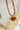 Enamel-Heart-Beaded-Necklace-Tortoiseshell-Fleastyle with a heart-shaped amber pendant on a textured background-Fleastyle