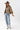 A woman wearing a cropped leopard-print cape-inspired jacket with a relaxed silhouette and a classic collared neckline, paired over a graphic t-shirt and a brown cowboy hat, jeans and cowboy boots-Leopard_Print_Cape_Jacket-FleaStyle
