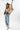 A woman wearing a cropped leopard-print cape-inspired jacket with a relaxed silhouette and a classic collared neckline, paired over a graphic t-shirt and a brown cowboy hat, jeans and cowboy boots-Leopard_Print_Cape_Jacket-FleaStyle