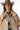 A woman wearing a cropped leopard-print cape-inspired jacket with a relaxed silhouette and a classic collared neckline, paired over a graphic t-shirt and a brown cowboy hat, jeans and cowboy boots-Leopard_Print_Cape_Jacket-FleaStyle