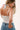 Woman wearing a white tank top, blue jeans and a Horseshoe Charm Scarf Necklace - Blue/Coral Bandana-Fleastyle