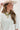 Woman wearing a painted flat-brimmed hat and a Love-Statement-Charm-Necklace-Gold-Fleastyle