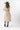 A smiling woman wearing a brown cowboy hat, a beige sleeveless vest with robe tie and oversized faux-fur collar, jeans and a white long-sleeve top, photographed against a clean white studio background-Fur Trimmed Sleeveless Duster Vest - Taupe