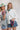 Two women wearing colorful necklaces a and painted cowboy hat against a plain background-Bandana_Charm_Necklace_-_Red_Gold-Fleastyle