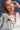 Woman wearing multiple necklaces with a blue denim background-Fleastyle