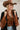 A woman wearing a pintuck shirt dress features a collared neckline, button-front design, defined tie waist and a flowy midi silhouette with a brown straw cowboy hat, a rust-brown ruffled blouseand light-wash blue jeans-Pintuck Waist Tie Front Midi Dress/Duster - Black