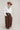 A woman wearing a brown straw cowboy hat, a structured blouse with ruffle detailing, western-inspired yoke seams, snap buttons and billowy long sleeves, paired with a brown midi skirt -Ruffle_Neck_Snap_Button_Blouse-FleaStyle