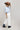 A model wearing a light blue knit short-sleeve top, modern barrel-leg silhouette, adjustable drawstring waist and utility-inspired seaming for a relaxed yet elevated fit, a brown straw cowboy hat, and blue boots--Drawstring_Barrel_Jogger_Pants_-_Ivory-FleaStyle