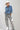 A woman wearing a light blue cropped denim relaxed denim shirt-jacket, an ivory cowboy hat, and high-waisted pant with allover snakeskin print and shimmering sequins--Cropped_Denim_Shacket-FleaStyle