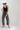 A woman wearing a black studded tank, easy barrel-leg silhouette leopard print jean, silver cowboy boots, and an ivory cowboy hat-Leopard_Print_Barrel_Jeans-FleaStyle