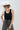 A woman wearing  an ivory cowboy hat, and wide-leg patterned pants and a form-fitting tank featuring a flattering scoop neckline with studded detailing for a subtle western edge-Studded Knit Tank Top - Black-FleaStyle