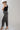 A woman wearing a black studded tank, easy barrel-leg silhouette leopard print jean, silver cowboy boots, and an ivory cowboy hat-Leopard_Print_Barrel_Jeans-FleaStyle