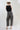A woman wearing  an ivory cowboy hat, and wide-leg patterned pants and a form-fitting tank featuring a flattering scoop neckline with studded detailing for a subtle western edge-Studded Knit Tank Top - Black-FleaStyle