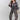 A woman wearing a charcoal gray oversized button-down shirt with a relaxed fit, voluminous sleeves and a soft bubble hem, leopard-print wide-leg jeans, silver cowboy boots, and a Texas trucker hat --Bubble_Sleeve_Button_Down_Top_-_Charcoal_Gray-FleaStyle