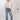 A woman wearing a cream blouse with dark polka dots, mid-rise cropped jeans with a silhouette fit through the hips and thighs and easy kick flare, and a dusty  blue cowboy hat-Mid-Rise_Cropped_Bootcut_Jeans-FleaStyle.