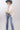 A woman wearing a cream blouse with dark polka dots, mid-rise cropped jeans with a silhouette fit through the hips and thighs and easy kick flare, and a dusty  blue cowboy hat-Mid-Rise_Cropped_Bootcut_Jeans-FleaStyle.