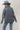 A woman wearing a western-style outfit featuring a playful Western Embroidered Patch Blazer with colorful embroidered patches, a dusty blue cowboy hat, denim denim jeans, and silver cowboy boots --Western_Embroidered_Patch_Blazer-FleaStyle