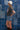 Woman in a trucker hat, Choosin' Texas Graphic T-Shirt - Pink- denim shorts and cowboy boots in front of a denim patchwork background-Fleastyle
