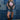 Woman in a trucker hat, Choosin' Texas Graphic T-Shirt - Pink- denim shorts and cowboy boots in front of a denim patchwork background-Fleastyle