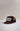 A dark brown trucker hat with a flat brim and white embroidered text reading 'LAGUNA BEACH' on the front, set against a neutral light gray background.