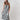 A woman modeling a sleeveless midi dress with bold black and white vertical stripes, paired with a yellow trucker hat and patterned shoes-Vertical Stripe Midi Dress - Black/Ivory