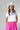 A woman wearing a bright pink pleated midi skirt with a white graphic t-shirt and an ivory cowboy hat-A-Line Midi Skirt - Hot Pink-FleaStyle