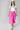 A woman wearing a bright pink pleated midi skirt with a white graphic t-shirt and an ivory cowboy hat-A-Line Midi Skirt - Hot Pink-FleaStyle
