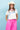A woman wearing a bright pink pleated midi skirt with a white graphic t-shirt and an ivory cowboy hat-A-Line Midi Skirt - Hot Pink-FleaStyle