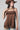 A woman wearing a brown satin camisole top with lace trim, a brown straw cowboy hat, and a green beaded necklace-Lace Trim Flowy Camisole Top - Brown