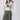 A woman  wearing a cream t-shirt with a large blue star applique, Washed Camo Pants with Ruched Ankle, an ivory cowboy hat-Denim Star Short Sleeve Graphic T-Shirt - Ivory-FleaStyle