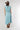 A woman wearing a brown straw cowboy hat, a light blue sleeveless crop top, and a matching pleated skirt, accessorized with a chunky gold necklace-Balloon Crop Top - Blue-FleaStyle