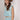 A woman wearing a brown straw cowboy hat, a light blue sleeveless crop top, and a matching pleated skirt, accessorized with a chunky gold necklace-Balloon Crop Top - Blue-FleaStyle
