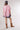 A woman wearing soft pink striped pattern, relaxed boxy silhouette and easy half sleevesshirt, paired with blue denim shorts, brown cowboy boots, and a navy blue baseball cap with a -FleaStyle