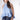 A woman wearing a light blue sleeveless ruffled top, dark blue paisley patterned denim shorts,a dusty blue cowboy hat-Halter Neck Sleeveless Tie Ruffle Top - Light Blue